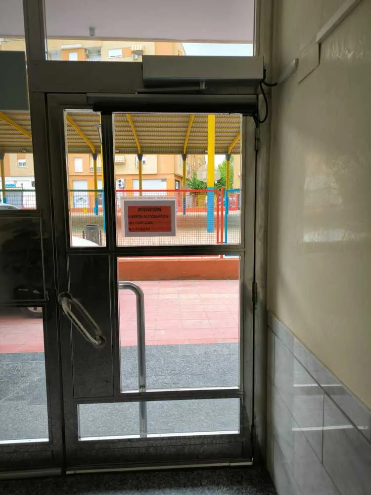 Puerta automática abatible instalada en un edificio